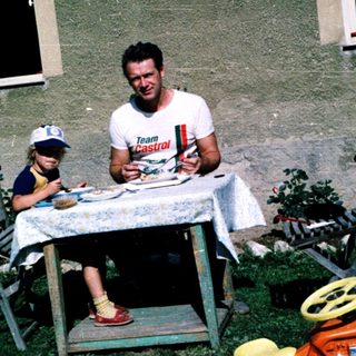 Family picnic outdoors near a house.