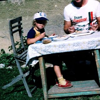 Family picnic outdoors near a house.