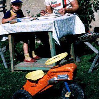 Family eating outdoors near a house.