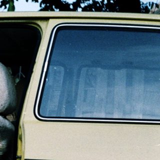 Four children sitting in open van door.