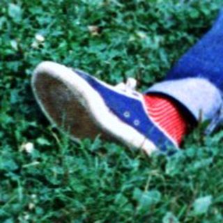 Boy playing with toy truck in grassy area.