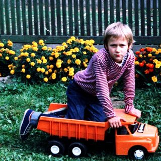 Two children playing with toy truck outdoors.