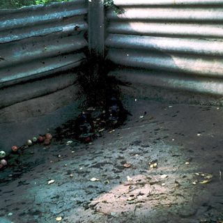 Abandoned, rusted metal structure with scattered debris.