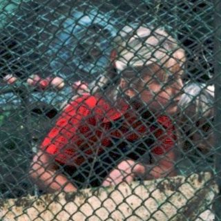 Children confined in makeshift metal cage.