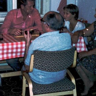 Family gathering around a table in a cozy indoor setting.