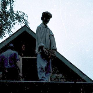 People on rooftop near house during sunset.