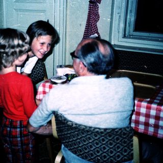 Family gathering playing board game indoors.