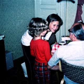 Family gathering playing board game indoors.