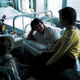 Hospital room with patient and visitors.