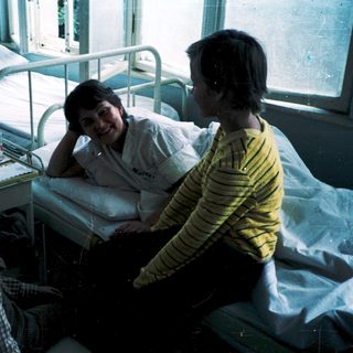 Hospital room with patient and visitors.