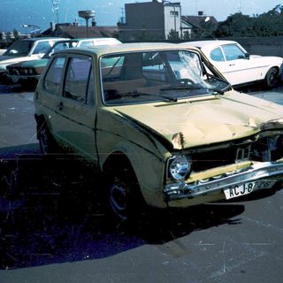 Damaged vintage car in parking lot.