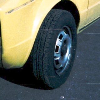 Yellow car with severe front damage, broken windshield.
