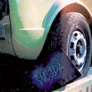 Severely damaged light green vehicle on tow truck.