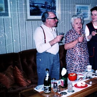 Family gathering indoors playing charades or guessing game.