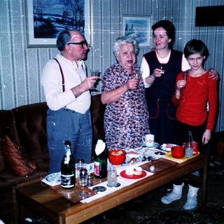 Family gathering indoors playing charades or guessing game.