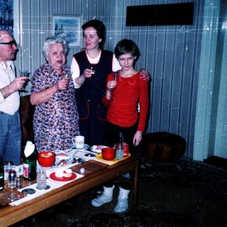 Family gathering indoors playing charades or guessing game.