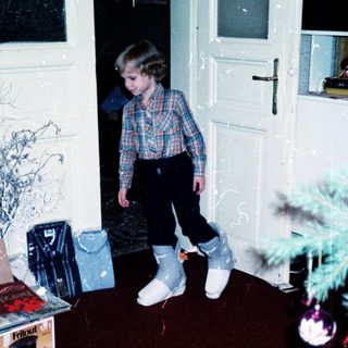 Child standing near open door in indoor playroom.