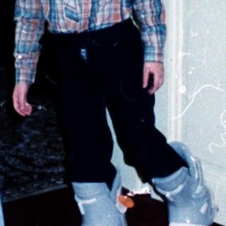 Child standing near open door in indoor playroom.