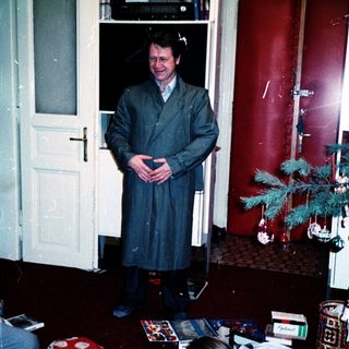 Christmas morning with man in robe and child opening gifts.