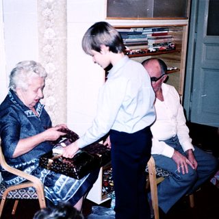 Three people playing a board game indoors.
