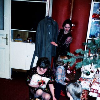 Family gathering opening holiday gifts indoors.