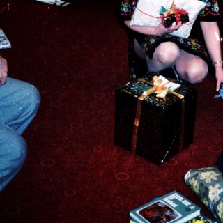 Family gathering opening holiday gifts indoors.