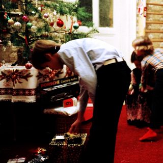 Family opening Christmas presents indoors.