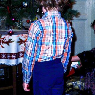 Two people decorating a Christmas tree indoors.