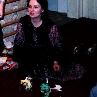 Family opening Christmas presents by tree.