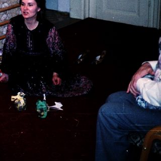 Family opening Christmas presents by tree.