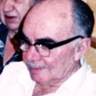 Family gathering with elderly man receiving gift.