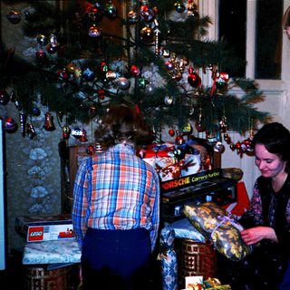 Family decorating Christmas tree indoors.