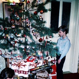 Family decorating Christmas tree with gifts.