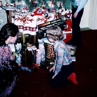 Family decorating Christmas tree with gifts.