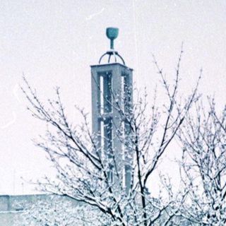 Snow-covered trees and distant church steeple.