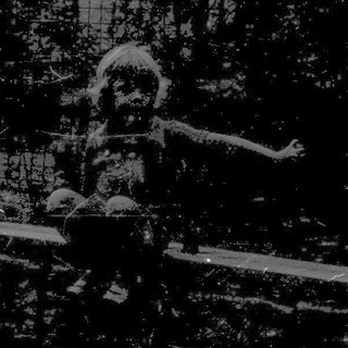 Child sitting on damaged bridge amid debris.
