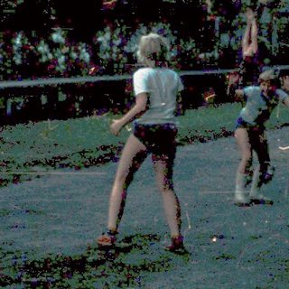 Children playing frisbee outdoors in a backyard.