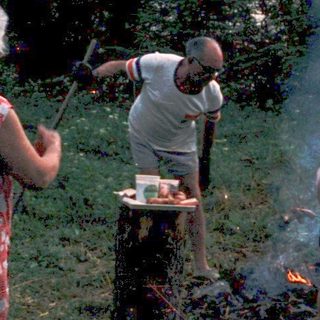 Family gathering around an outdoor campfire.