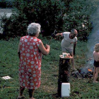 Family gathering around an outdoor campfire.