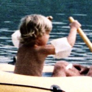 Family enjoying paddle boating on calm lake.