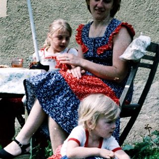 Family enjoying outdoor picnic by house.