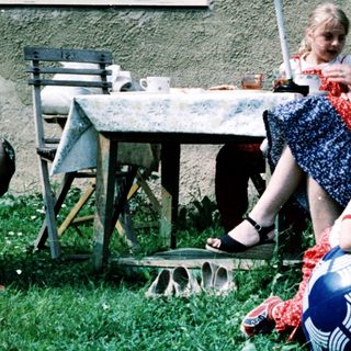 Family enjoying outdoor picnic by house.
