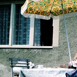 Family enjoying outdoor picnic by house.