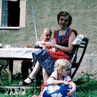 Family enjoying outdoor picnic by house.