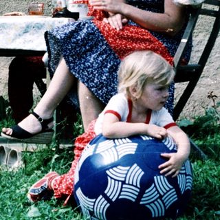 Family enjoying outdoor picnic by house.