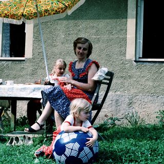 Family enjoying outdoor picnic by house.