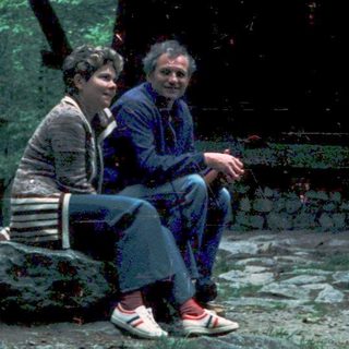 Two people sitting together outdoors under a shelter.