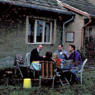 People gathered outdoors near a rustic building.