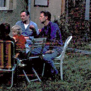 People gathered outdoors near a rustic building.