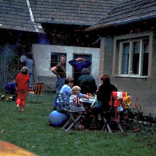 People gathering outdoors near a house.